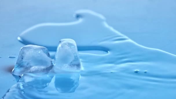 Twee Ijsblokjes Smelten Helder Glas Gevuld Met Water Kristalheldere Druppels — Stockvideo