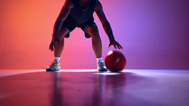 Dynamiczny Pokaz Atletyzmu Umiejętny Koszykarz Pokazuje Technikę Dryblingu Piłką Gradientowym — Wideo stockowe