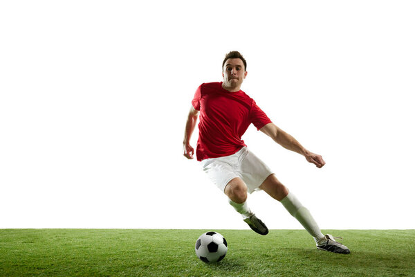 Man, football player in motion during game training, running on filed with ball isolated on white background. Concept of professional sport, game, competition, tournament, action, active lifestyle