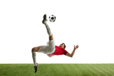 Kararlı genç bir adam, maç boyunca hareketli futbol oyuncusu, antrenman, topa vurmak ve beyaz arka planda izole bir şekilde düşmek. Profesyonel spor, oyun, rekabet, turnuva, aksiyon kavramı