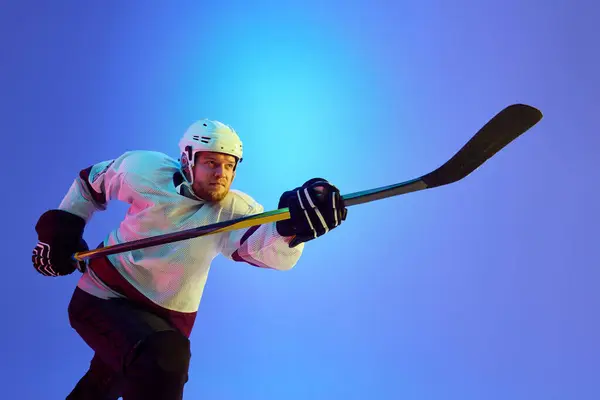 Homme Ambitieux Joueur Hockey Posant Avec Bâton Montrant Détermination Contre Photo De Stock