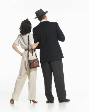 Retro-stil şık kostümlü kadın ve erkek beyaz arka planda izole edilmiş bir yerde dikilip bakıyorlar. Retro ve vintage kavramı, moda, romantizm, ilişki