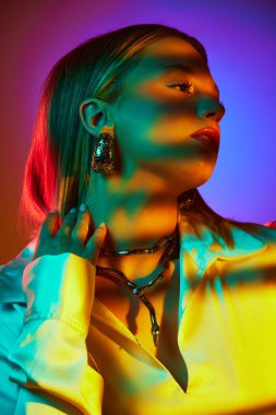 Klasik tarzın modern mücevher kombinasyonuyla birleşimi, neon ışıkta arka planda zarif bir kadın pozu. Modern moda kavramı, moda tarzı, güzellik, gençlik kültürü