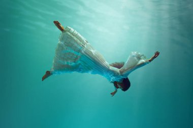 Sihirli sualtı macerasıyla ilgili fantezi kitabı. Suyun altında havada süzülen genç bir kız. Sürrealizm kavramı, güzellik, gizem ve fantezi, özgürlük