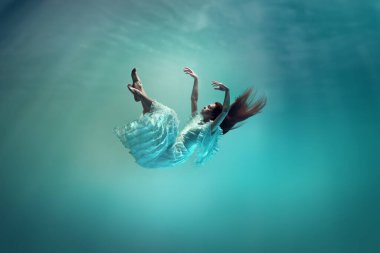 Okyanusun altında gizlenmiş sihir ve gizem. Suyun altında yükselen zarif genç kız huzur ve sükunet arıyor. Sürrealizm kavramı, güzellik, gizem ve fantezi, özgürlük