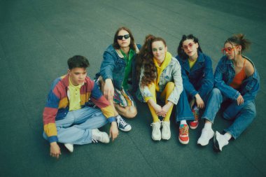 90 'ların şık kıyafetleri içinde çatıda poz verip eğlenen bir grup arkadaş. Şehir tarzı toplanma. 90 'ların kavramı, moda, gençlik kültürü, eski tarz eğilimler