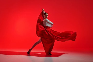 Güzel bir kadın, zarafetle flamenko yapıyor, dinamik hareketler geleneksel İspanyol dansının ateşli kalbini yansıtıyor. Hareket sanatı, klasik dans, güzellik, festival kavramı
