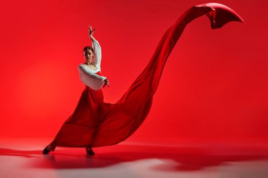 Her adımda tutku. Zarif kadın, profesyonel dansçı, kırmızı arka plana karşı flamenko yapıyor. Hareket sanatı, klasik dans, güzellik, festival kavramı