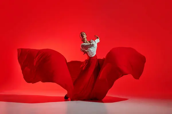 优雅和精力 美丽的女人穿着华丽而引人注目的服装 在鲜红的背景下表演着艺术的弗拉门戈舞曲 运动艺术的概念 古典舞蹈 — 图库照片