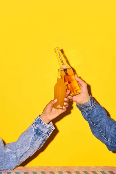 Male Female Hands Holding Bottles Beer Lemonade Clinking Bright Yellow — Stock Photo, Image