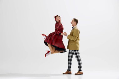 Canlı bir dans performansı, 20. yüzyılın ortalarından kalma, beyaz stüdyo arka planında izole dans eden genç bir çift. Sanat anlayışı, retro ve vintage, hobi, eğlence, 20 'ler