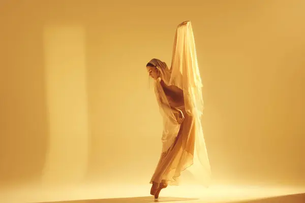 光之舞艺术芭蕾舞女舞者穿着飘逸的金黄色衣服 在沙色背景下进行富有创意的优美表演 艺术概念 古典舞蹈 — 图库照片#