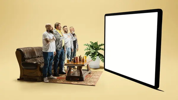 在比赛开始前 男人们站在沙发旁边 看着3D的屏幕模型 唱着足球赞美诗 锦标赛的概念 — 图库照片#