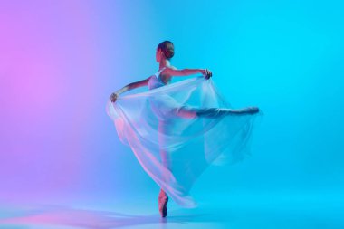 Akan beyaz kumaşlı balerin canlı gradyan arkaplana karşı neon ışığında hareketli bir pozla yakalandı. Grace hareket halinde. Sanat, hareket, klasik ve modern, güzellik, moda kavramı. Ad