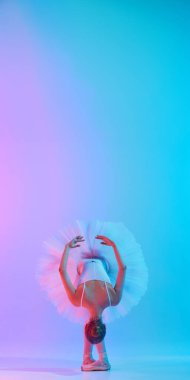 Beyaz etekli ve tulumlu balerin ve parlak arkaplana karşı neon ışıkta eğik poz veriyor. Uzayı kopyala Sanat, hareket, klasik ve modern birleşme, güzellik ve moda kavramı.