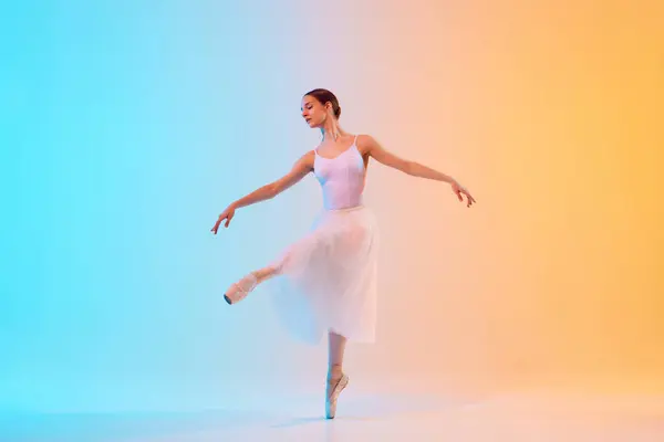Young Ballerina White Tutu Pointe Practicing Dance Moves Neon Light — стоковое фото