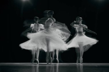Bulanık, dinamik, güzel balerinlerin hareket halindeki beyaz balerinleri dans ederken ruhani şekiller oluşturuyor. Tek renkli olsun. Güzellik kavramı, klasik ve modernlik, çağdaş sanat. Ad