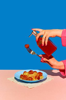 Tuhaf Mutfak Sanatı. Mavi arka planda spagetti ve köfte yemeğinin sanatsal ve eğlenceli temsili. Sabun makinesinde ketçap. Yaratıcı fotoğrafçılık kavramı, pop sanat tarzı, hayal gücü.