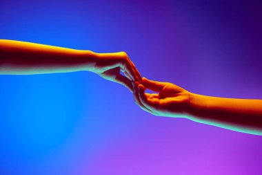 Çocuklar el kol hareketi yapıyor, bir arada tutuyorlar, neon ışıklarındaki mavi arkaplana karşı birlik, ortaklık ve bağlantıyı sembolize ediyorlar. İlan için boşluk kopyala, metin yaz. Pankart.