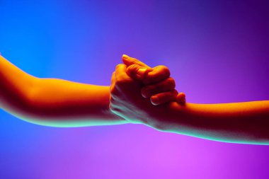 Çocuklar el kol hareketi yapıyor, el ele tutuşuyor, neon ışıkta mor arkaplanda titreşiyor. Destek. İlan için boşluk kopyala, metin yaz. Pankart.