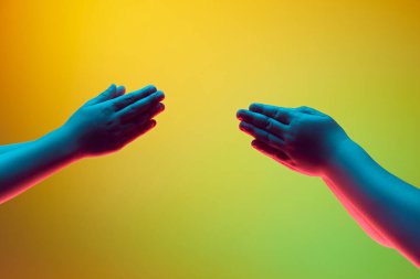 Çocuk, el hareketleriyle, neon ışıkta yeşil arka plan rengine karşı hareket ediyor. Alkışlayın, çalın. İlan için alanı kopyala