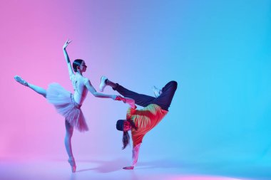 Klasikler modernlikle buluşur. Yumuşak bir genç kız, neon arka planda hip hop dansı yapan etkileyici bir adamla dans eden bir balerin. Klasik ve modern dans kavramı, performans