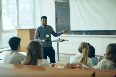 Profesyonel Gelişim Atölyesi. Genç bir adam, bir grup ilgili öğrencinin atölyesini yönetiyor. İyi aydınlatılmış bir sınıf. Eğitim kavramı, gençlik, atölye, bilgi