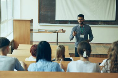 Afro-Amerikalı genç bir adam, üniversite sınıfında oturan çok ırklı öğrencilere ders veren bir öğretmen. Eğitim kavramı, gençlik, atölye, bilgi