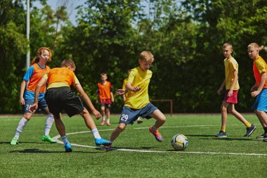 Canlı spor kıyafetleri içindeki gençler takım çalışmasını ve stratejisini vurgulayarak hassas ve hızlı bir şekilde futbol manevrası yapıyorlar. Açık hava oyunu. Spor, okul, çocukluk, hobi, aktif yaşam tarzı kavramı