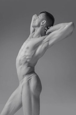 Siyah ve beyaz, tanımlanmış, kaslı, çekici vücudu olan, antika heykel gibi poz veren üstsüz bir adamın yaratıcı fotoğrafları. Kuvvet. Vücut estetiği, insan doğası ve güzelliği kavramı.