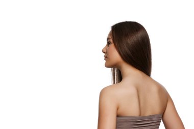 Mükemmel kahverengi saçlı ve beyaz arka planda mükemmel korunmuş ciltli güzel bir genç kızın arka plan görüntüsü. Doğal güzellik kavramı, saç bakımı, kozmetik ürünler reklamları.