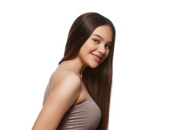 İyi korunmuş, pürüzsüz bir teni ve beyaz arka planda izole edilmiş parlak saçları olan gülümseyen genç bir kadının portresi. Doğal güzellik kavramı, saç ve cilt bakımı, kozmetik ürünler. İlan için alanı kopyala