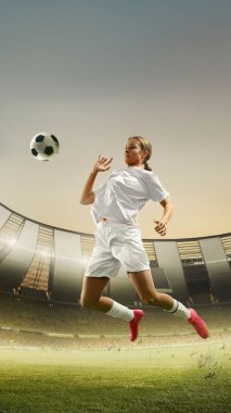 Dikey görüntü, odaklanmış genç bir kız, hareket halinde bir futbolcu, hareket, göğüsle topa vurmak. Açık hava stadyumunun 3D görüntüsü. Tribün hayranlarla dolu. Spor, turnuva, oyun kavramı