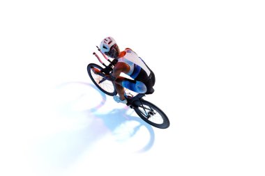 Dövmeli kadın bisikletçi, kask takıyor ve çok renkli bisiklet kıyafeti giyiyor, beyaz arka planda izole edilmiş, neon ışıklı yarış bisikleti sürüyor. Spor anlayışı, rekabet, turnuva. İzometrik görünüm