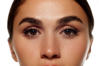 Doğal kirpikler, rimel ve kaş bakımı. Beyaz arka planda izole edilmiş, lekesiz, temiz bir kadın görüntüsü. Kadın güzelliği, deri ve vücut bakımı, kozmetik ve kozmetik kavramı