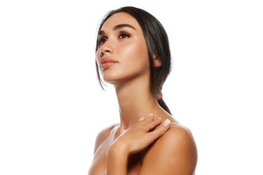 Doğal güzellik, estetik. Siyah saçlı, at kuyruklu çekici genç bir kadın, iyi korunmuş bir cilt, beyaz arka planda izole edilmiş dolgun dudaklar. Güzellik, cilt ve vücut bakımı, kozmetik ve kozmetik konsepti