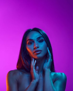 Şehvetli güzellik, estetik. Siyah saçlı çekici bir genç kadın, iyi korunmuş bir ten, mor arka planda dolgun dudaklar. Güzellik, cilt ve vücut bakımı, kozmetik ve kozmetik kavramı