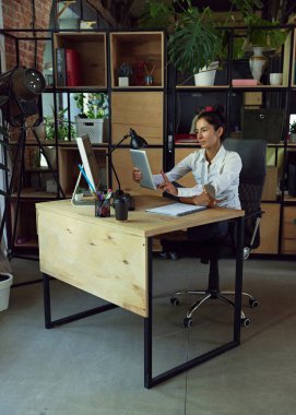 Vay canına, dostum. Ofis çalışanı çalışma masasında oturuyor, modern ofis ayarlarına karşı tablet üzerinde çalışıyor. İş hayatı kavramı, iş ve spor arasındaki denge, iş