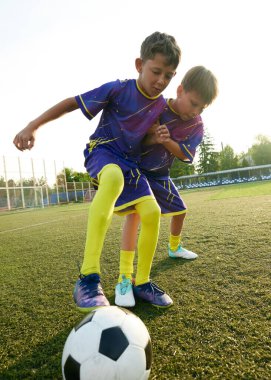 Dikey görüntü. Futbol maçında çocuklar tutkularını ve enerjilerini göstermek için futbol için şiddetli bir rekabete giriştiler. Spor, çocukluk, eğitim, başarı, aktif yaşam tarzı kavramı