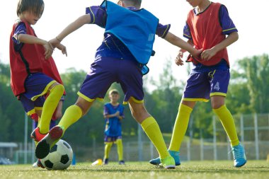 Genç oğlanların dinamik görüntüsü, açık havada futbol antrenmanı yapan çocuklar, topla koşan yeşil kız, zafer için yarışıyor. Spor, çocukluk, eğitim, başarı, aktif yaşam tarzı kavramı