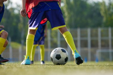Spor giyiminde bacaklara odaklanmış, futbol oyuncuları sahada top oynuyor, top sürüyor, top sürüyor. Spor okulu. Spor, çocukluk, eğitim, başarı, aktif yaşam tarzı kavramı