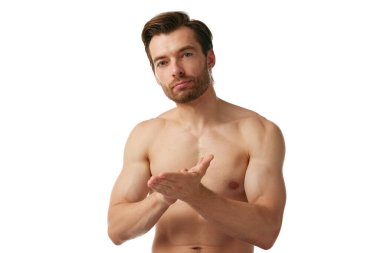 Yakışıklı, üstsüz, kaslı adam beyaz arka planda izole edilmiş sakal ve saç için stil ağdası yapıyor. Bakım için özel kozmetik ürünleri. Erkek güzelliği, cilt bakımı, kozmetik, kozmetik