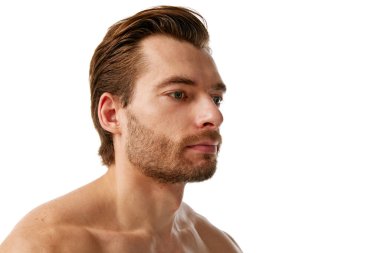 Cildi ve saçı bakımlı yakışıklı bir adamın portresi beyaz arka planda izole edildikten sonra dikkat edilmesi gerektiğini gösteriyor. Erkek güzelliği, cilt bakımı, kozmetik, kozmetik