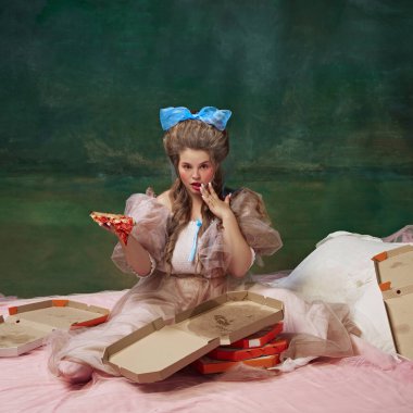 Yemek reklamları. Çekici genç bir kadının portresi, yeşil arka planda bir dilim pizzayla yatakta oturuyor. Tarih kavramı, barok sanatı, çağların karşılaştırması.