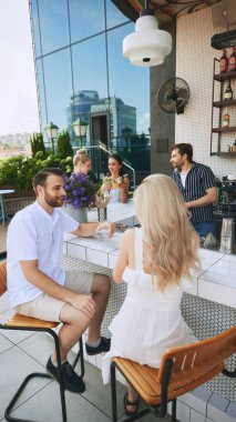 Genç güzel insanlar, barda oturan erkekler ve kadınlar kokteyl ve güzel sohbetin tadını çıkarıyorlar. Modern bar, restoran atmosferi. Arkadaşlık kavramı, parti, eğlence, kutlama, rahatlama.