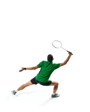 Odaklanmış bir adamın arka planı, yeşil tişörtle hareket eden badminton, raketle top oynayan, beyaz arka planda izole edilmiş pratik yapan. Spor anlayışı, rekabet, aktif yaşam tarzı