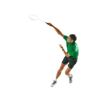 Yeşil spor giyim giymiş dinamik genç adam görüntüsü, raketle hareket eden badminton oyuncusu, beyaz arka planda izole edilmiş maça hazırlanıyor. Spor anlayışı, rekabet, aktif yaşam tarzı