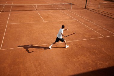 Genç rekabetçi bir adamın yoğun odak noktası, tenis oyuncusu raket, antrenman ve yaklaşan şampiyonluk maçına hazırlanıyor. Spor, rekabet, aktif ve sağlıklı yaşam tarzı konsepti