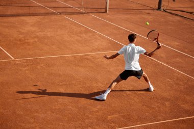 Sarayda güç ve dayanıklılık. Raketle hareket eden erkek tenisçinin arka görünüşü, top almaya, antrenman yapmaya ve oynamaya hazır olduğunu gösteriyor. Spor anlayışı, rekabet, aktif yaşam tarzı