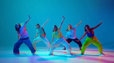 Genç dansçılar yaratıcılıklarını ve enerjilerini güçlü hip hop danslarıyla neon arka planda Cyan mavisi ile ifade ederler. Modern dans stilleri, gençlik kültürü, aktif yaşam tarzı kavramı